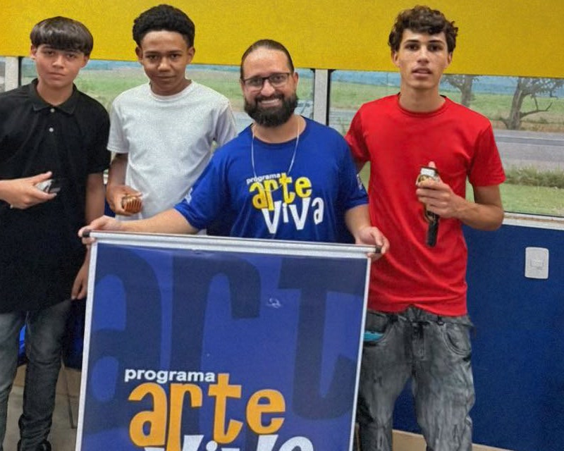 Integrantes do Programa Arte Viva na Carreta da Saúde, em Patrocínio, com o banner do programa