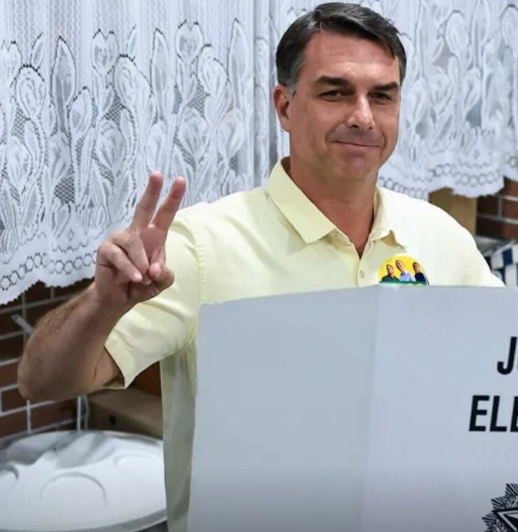 Flávio Bolsonaro faz o sinal de vitória ao votar, imagem usada na cobertura do Datafolha segundo turno