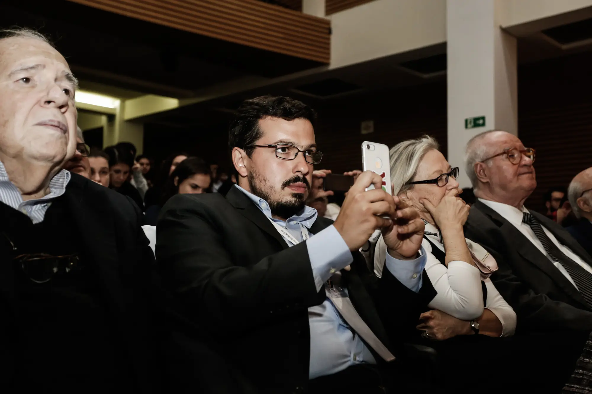 Guilherme Amado fotografa com o celular em evento da Abraji em 2018, na matéria sobre o caso Guilherme Amado