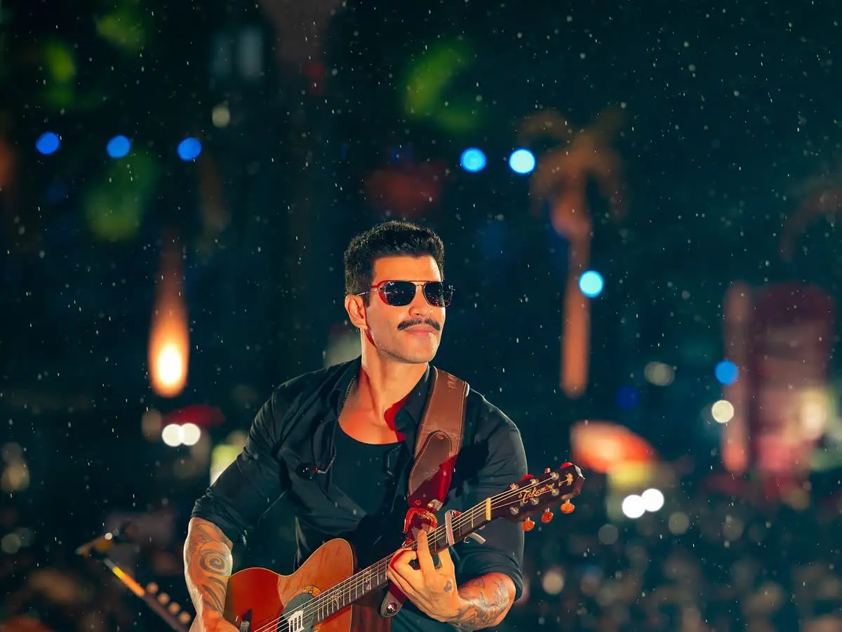 Gusttavo Lima de óculos escuros toca violão em show em Extrema, Minas Gerais
