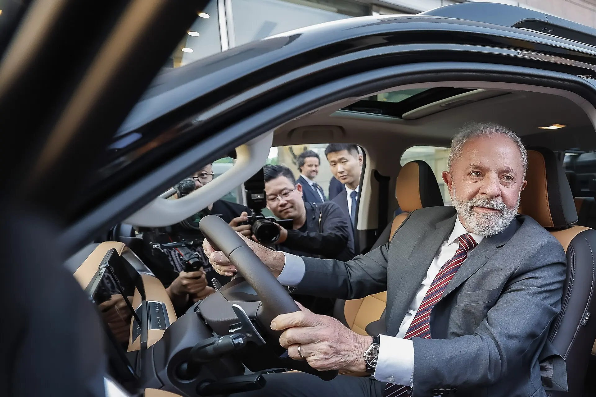 Lula ao volante de carro da GWM em Pequim, foto original usada na ilustração sobre o imposto de carros elétricos