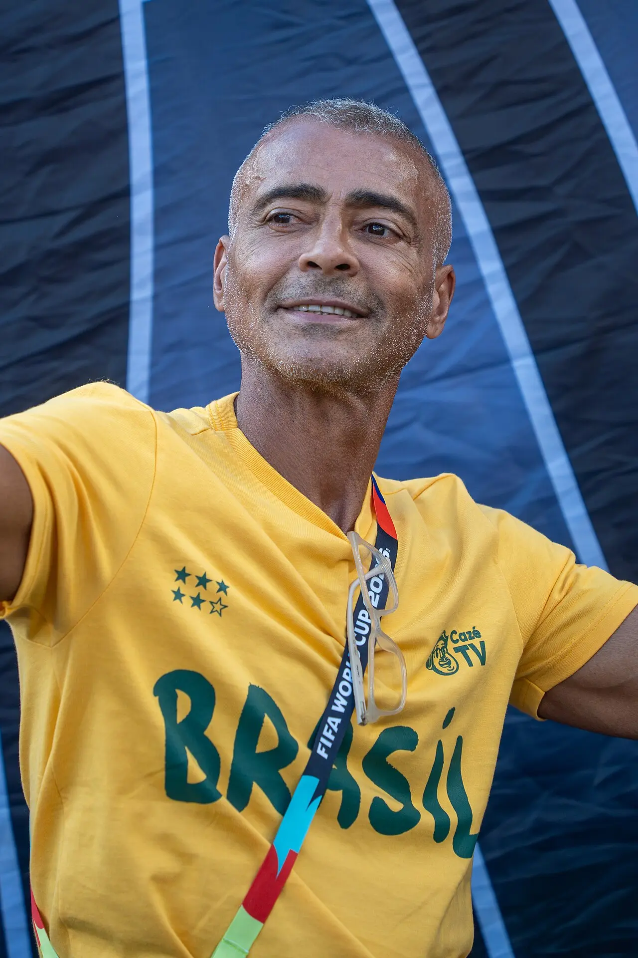 Romário sorri com camisa amarela do Brasil no estádio, meses antes do encontro de Kaio Jorge e Romário