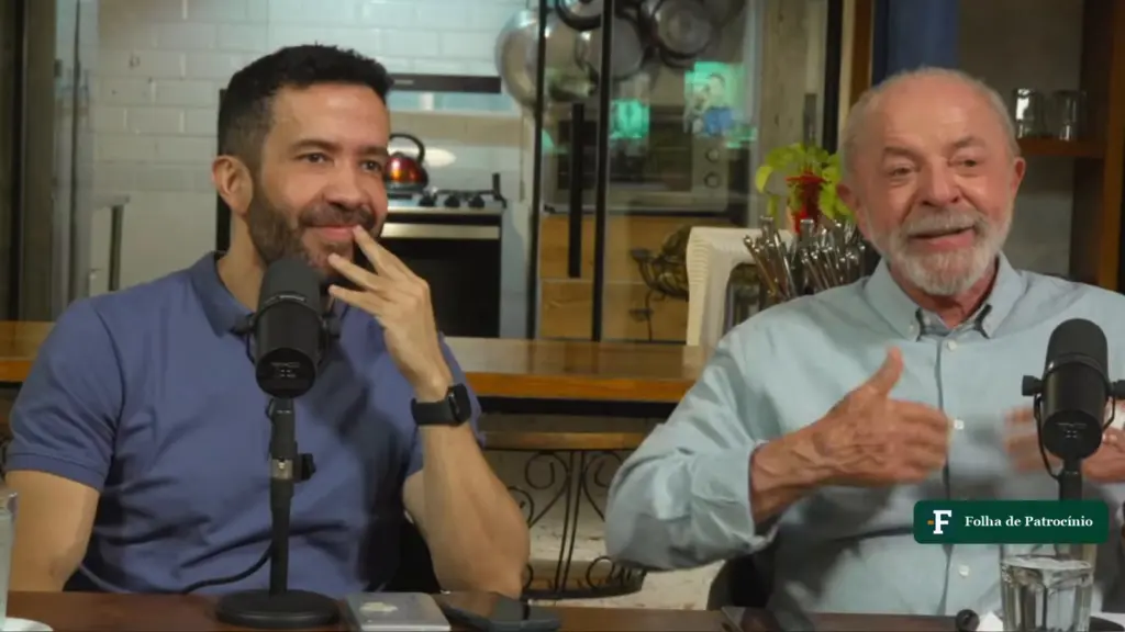 Live de Janones: André Janones e Lula sentados à mesa com microfones em transmissão do canal do presidente