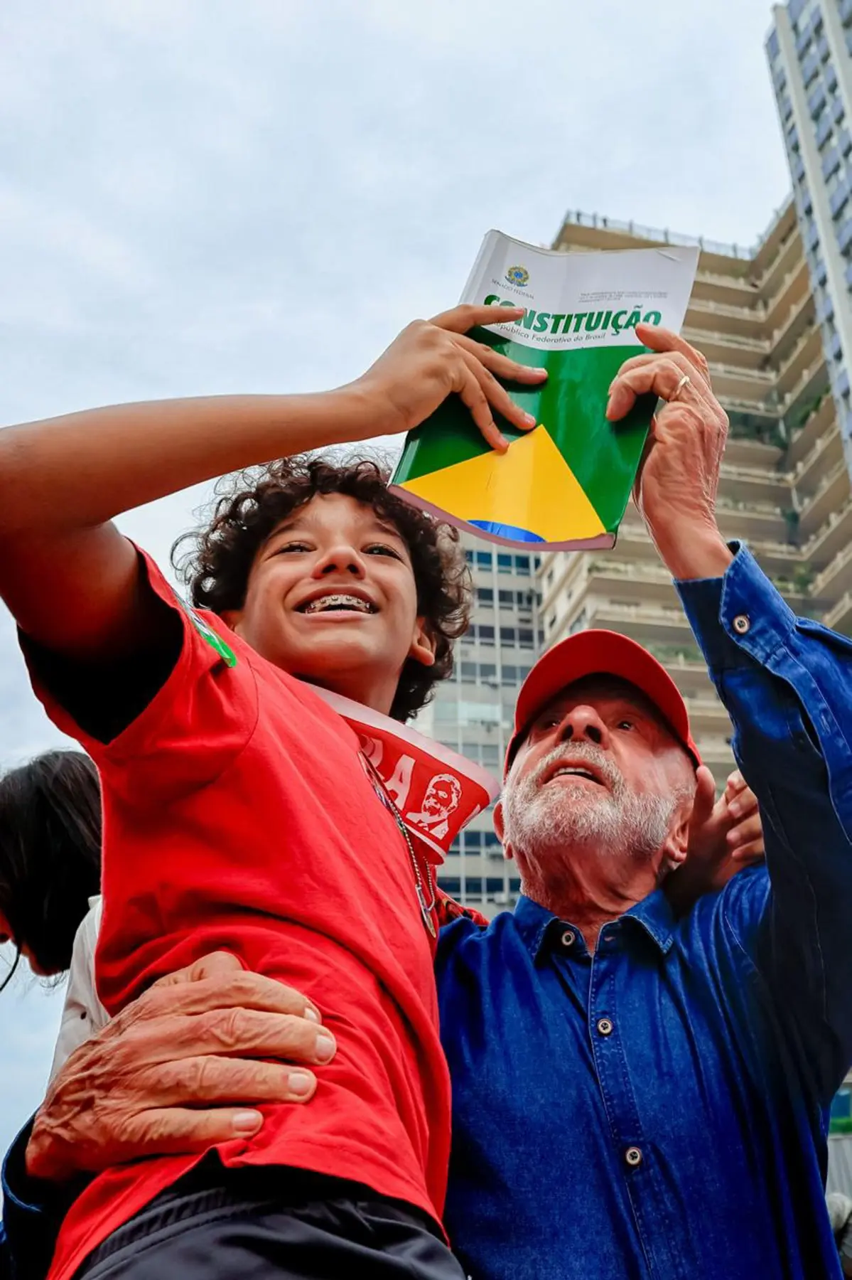 Lula é reeleito: o presidente segura um menino que ergue um exemplar da Constituição na Avenida Paulista