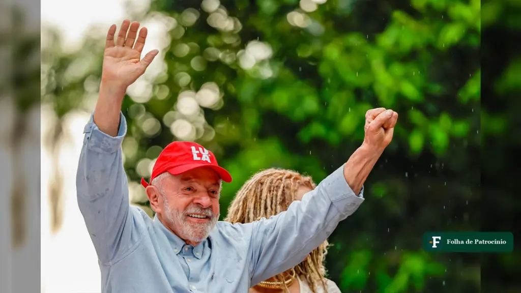 Lula em BH, de boné vermelho, acena com os dois braços erguidos em ato na Praça da Liberdade