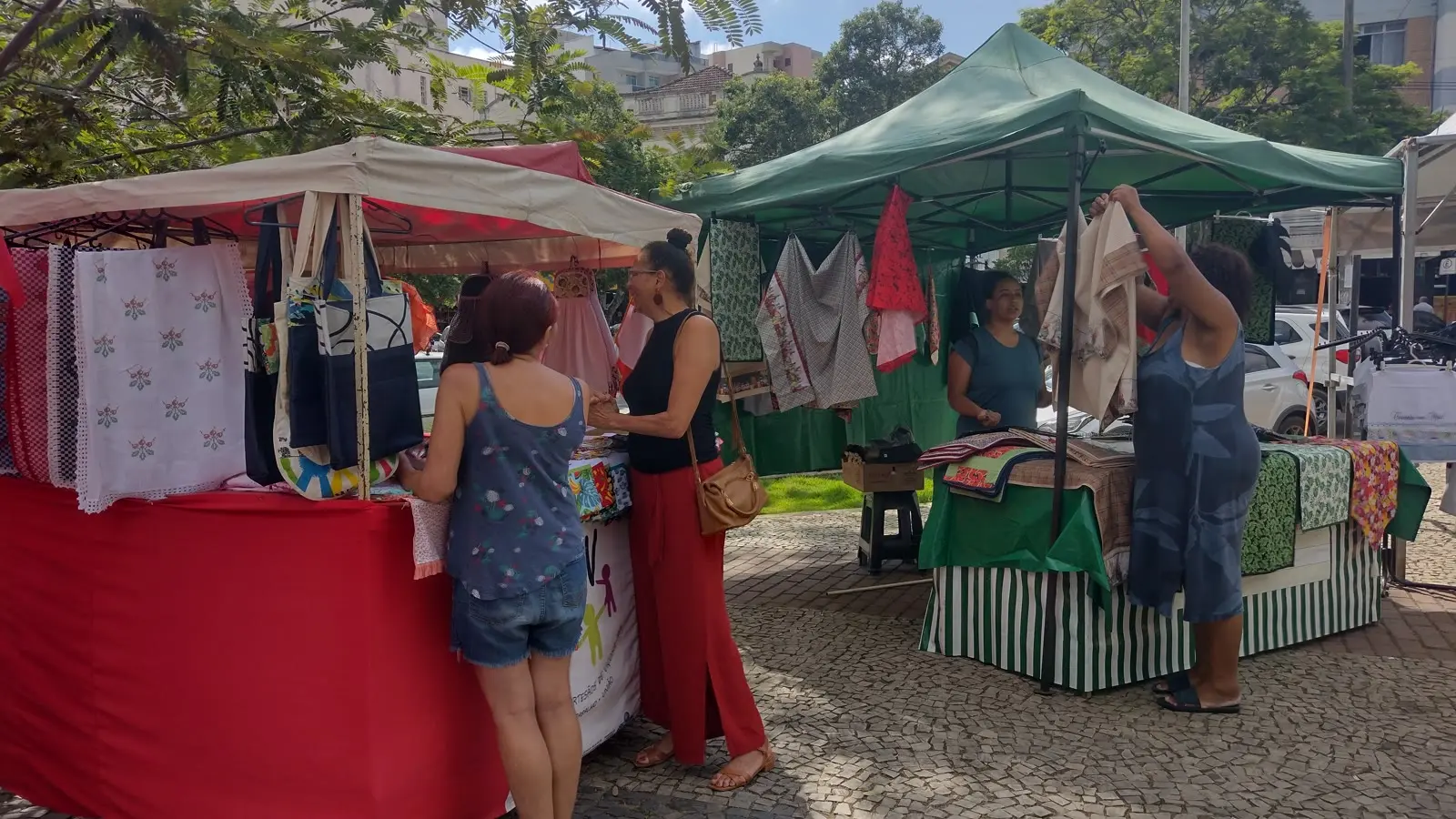 Microempreendedores atendem clientes em feira de artesanato na praça central de Viçosa, em Minas Gerais, ilustrando a lei para MEIs