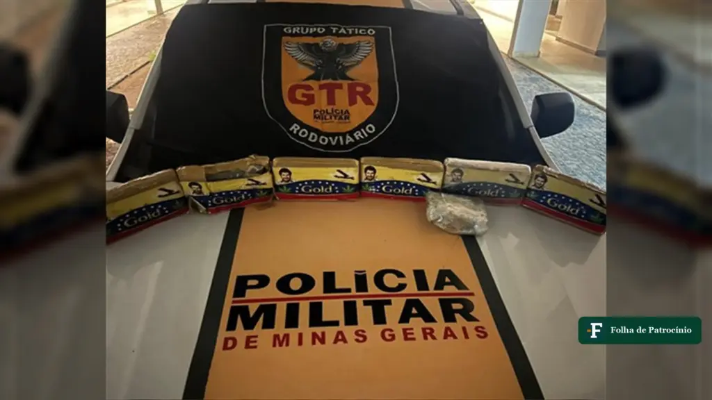 Tabletes de maconha apreendidos na MG-190 enfileirados sobre o capô de uma viatura da PM Rodoviária