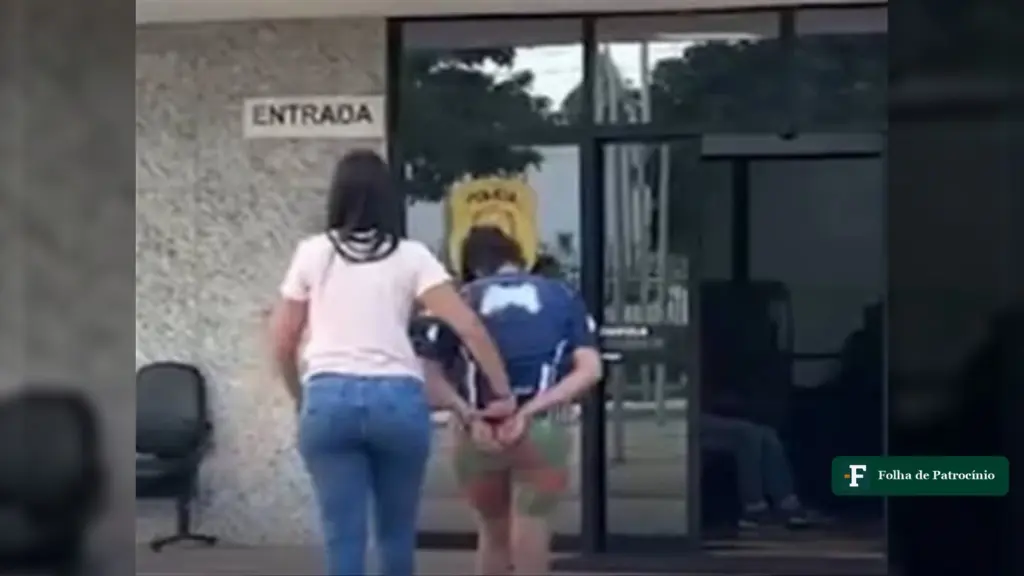Policial conduz a mãe presa em Brazlândia, algemada, para dentro de uma delegacia