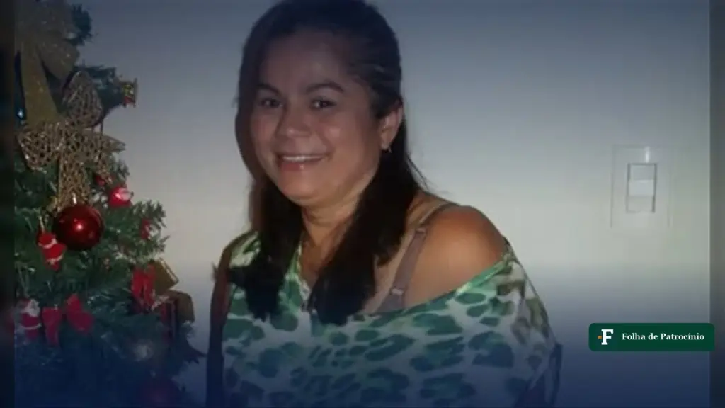 Maria Darlene Carvalho Souza sorri ao lado de uma árvore de Natal, em retrato