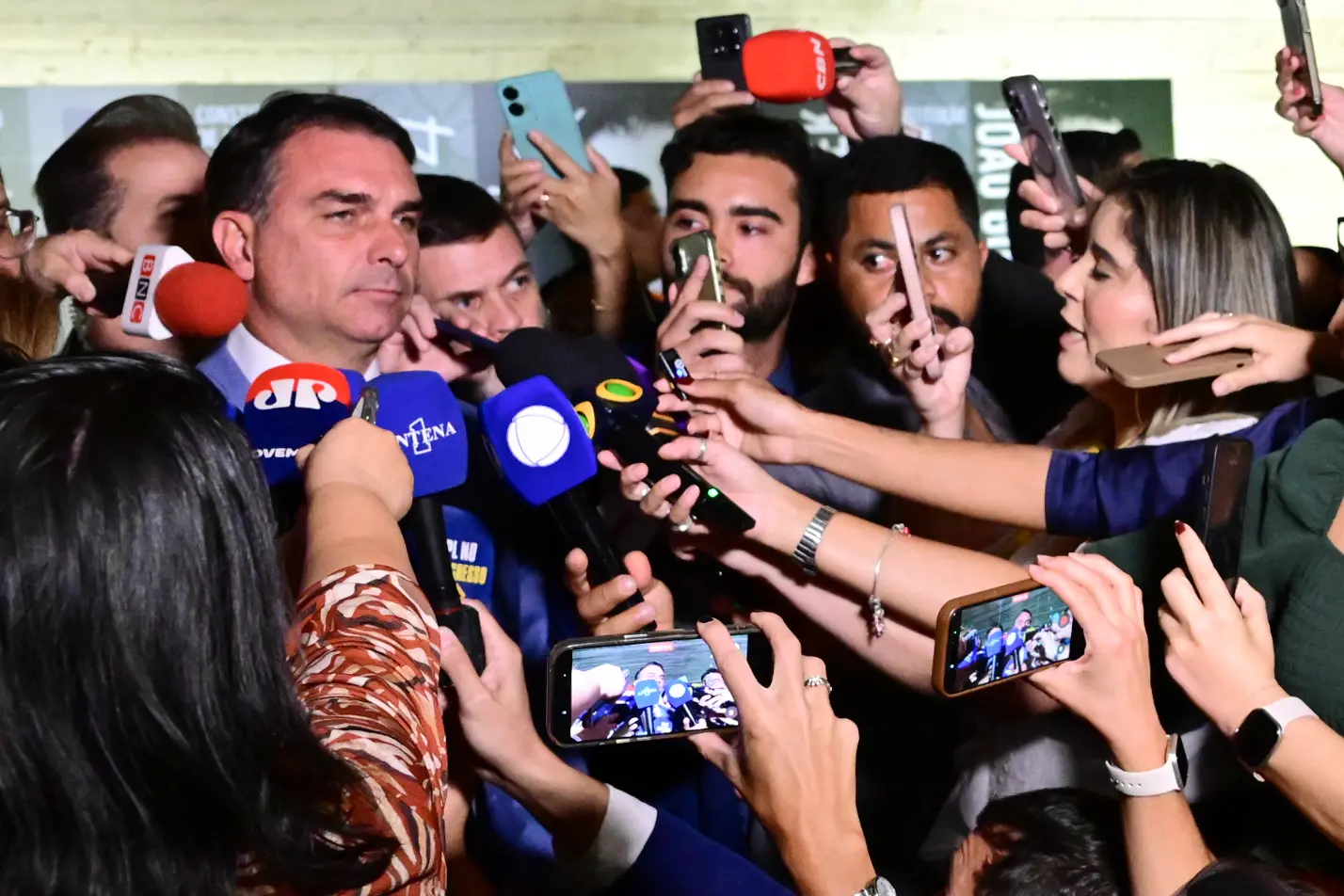 Senador Flávio Bolsonaro cercado por microfones e celulares de jornalistas no Senado, em setembro de 2026
