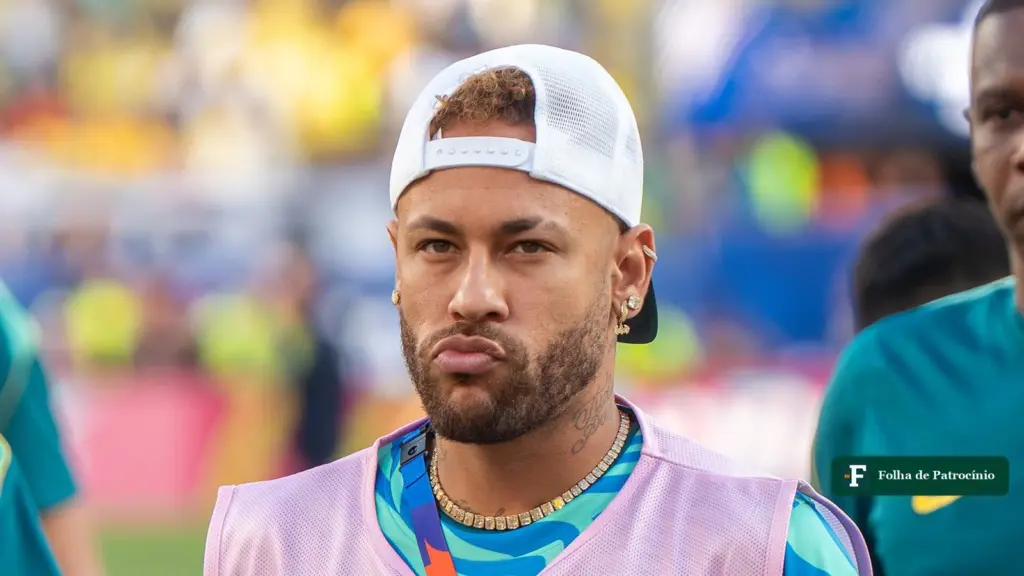 Neymar de boné branco virado para trás e colete rosa, em atividade da seleção brasileira