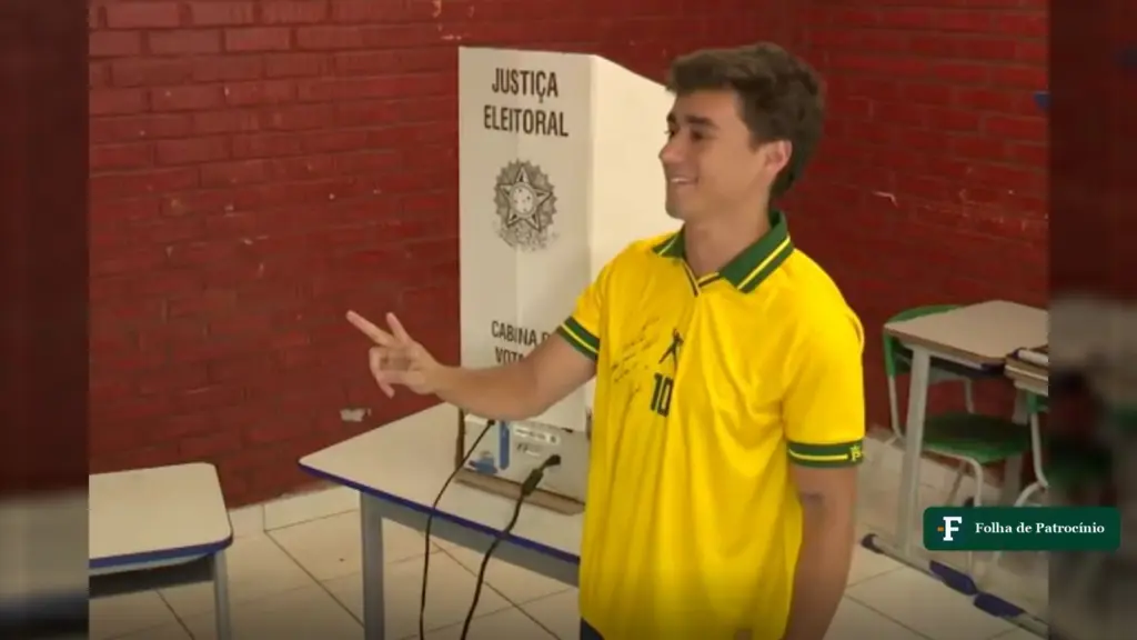 Nikolas Ferreira de camisa da Seleção faz sinal ao lado da urna, momento em que Nikolas vota em BH