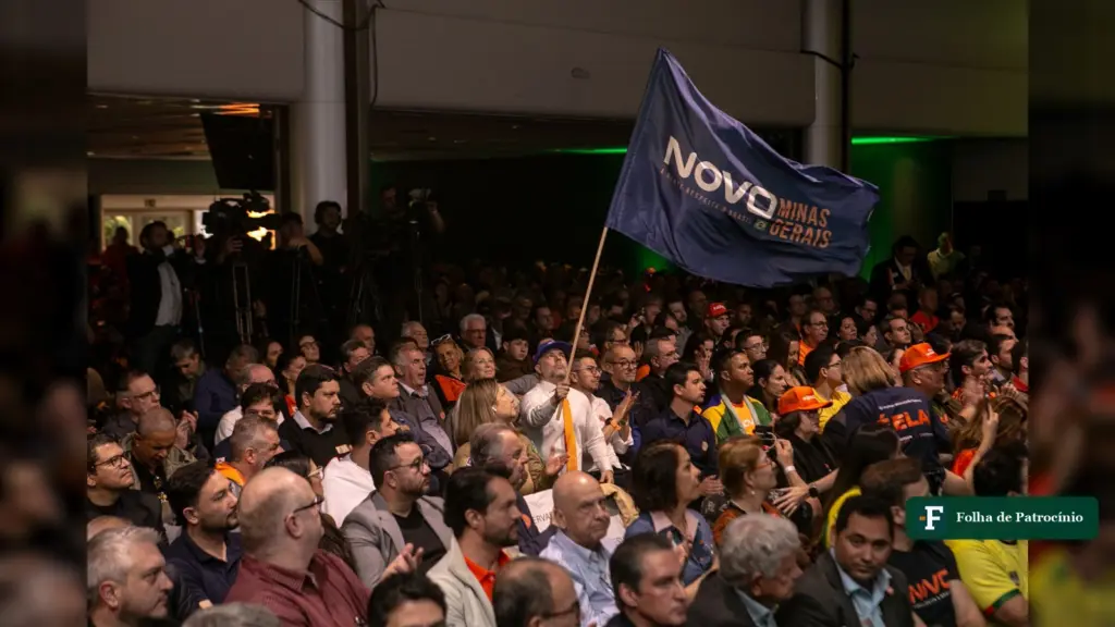 Militantes do Novo em Minas com a bandeira do partido em encontro estadual