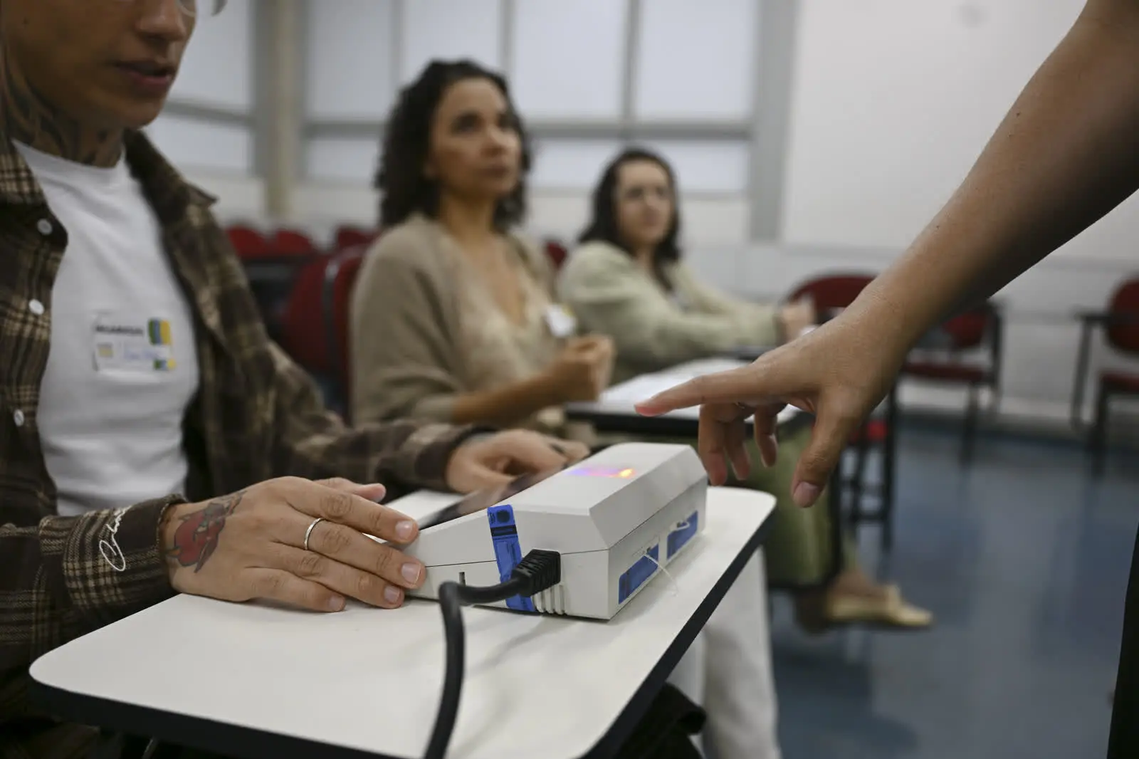 Mesário e urna eletrônica em seção eleitoral, em foto de arquivo do primeiro turno, antes do ônibus de graça em Patrocínio no segundo turno