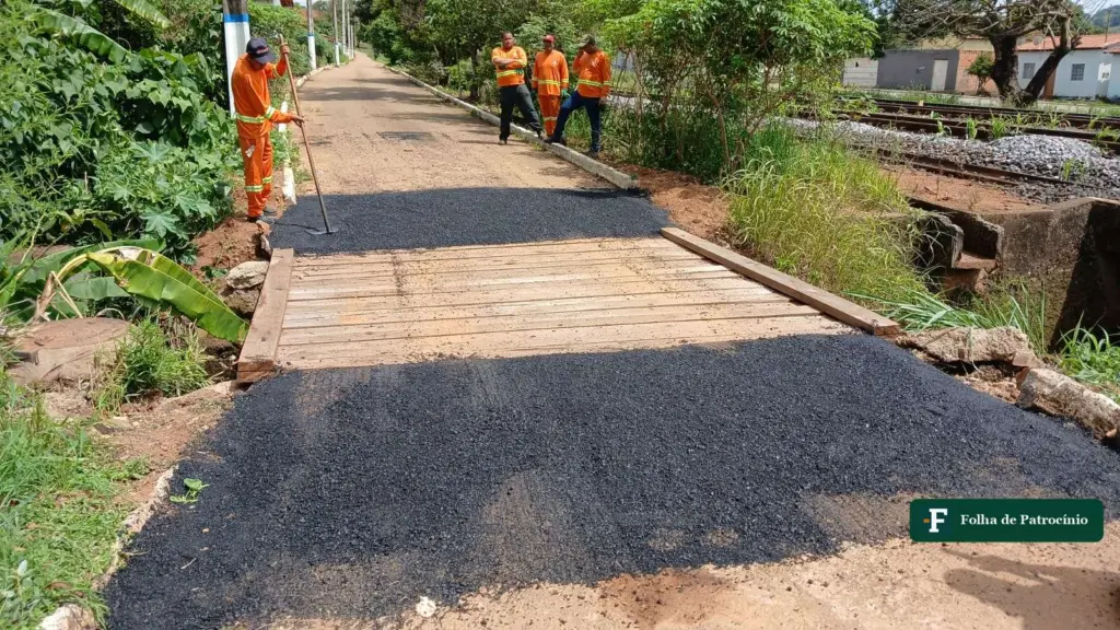 Servidores aplicam asfalto junto a uma ponte de madeira na operação tapa-buracos em Patrocínio