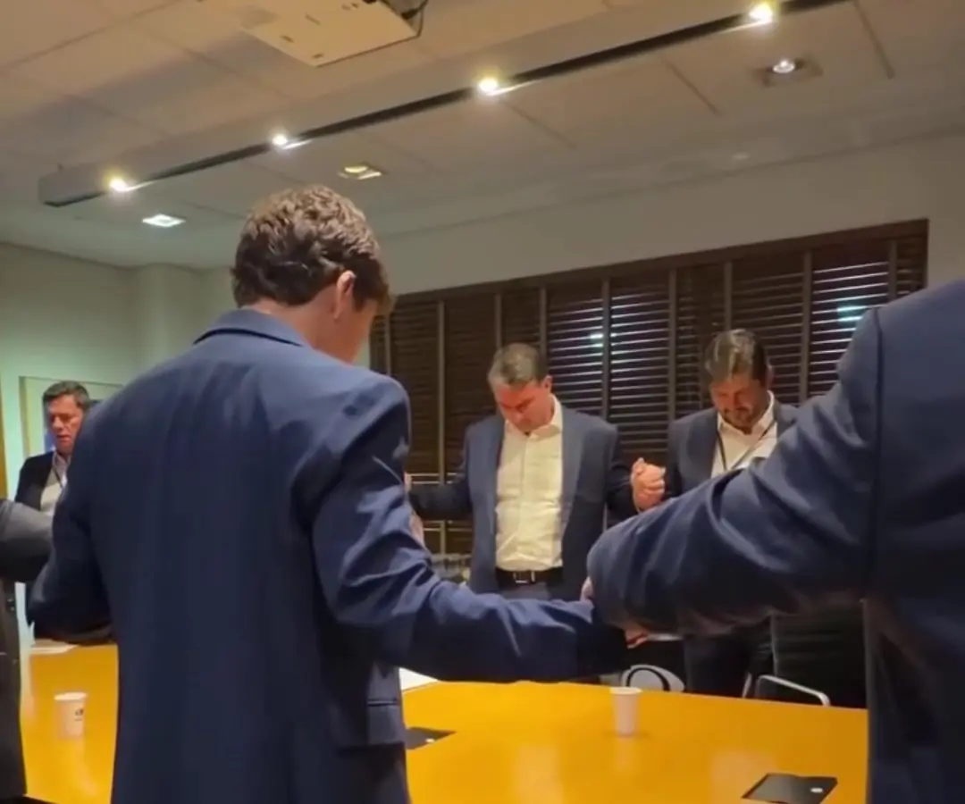 Pai-Nosso antes do debate: Flávio Bolsonaro reza de mãos dadas com a equipe numa sala da Band