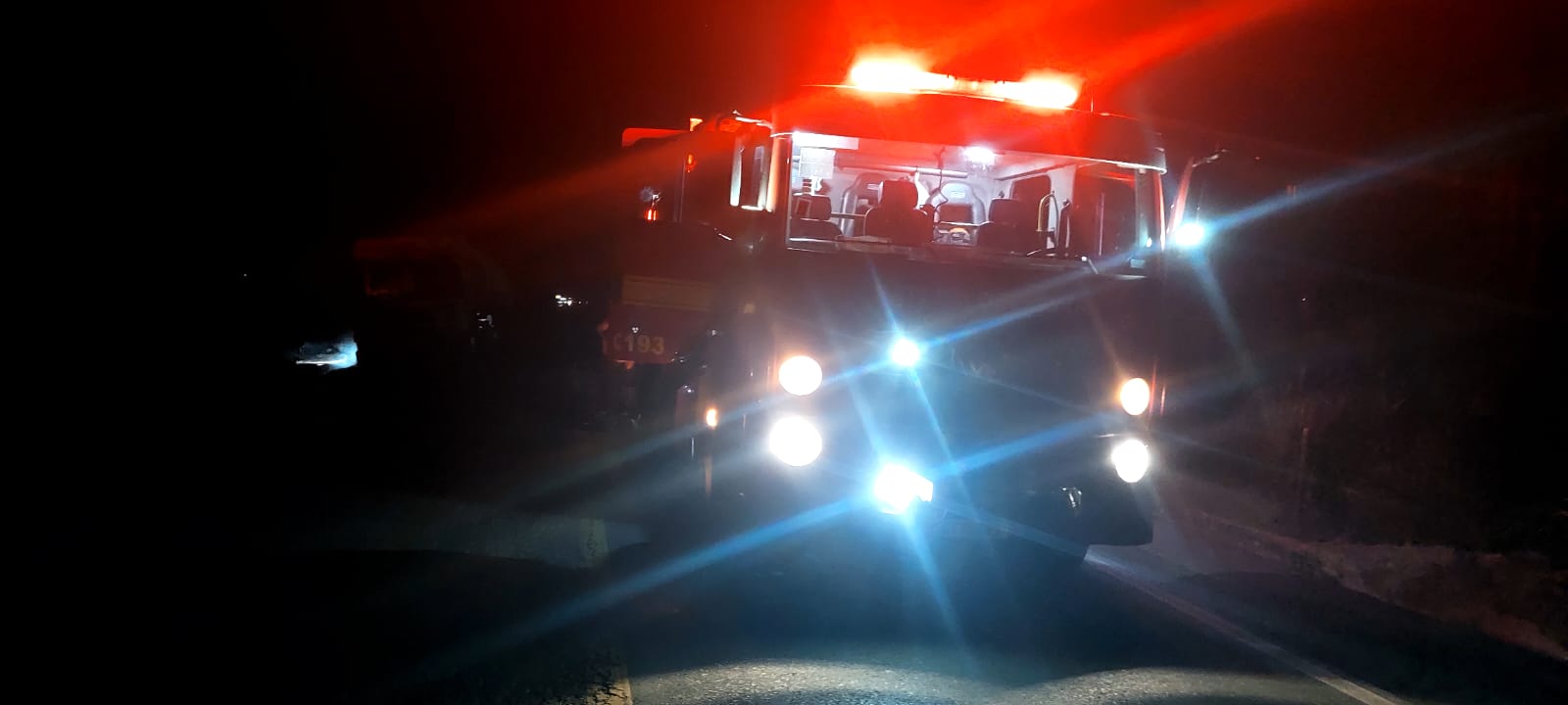 Viatura do Corpo de Bombeiros com giroflex aceso na rodovia durante o atendimento ao caminhão-tanque com álcool