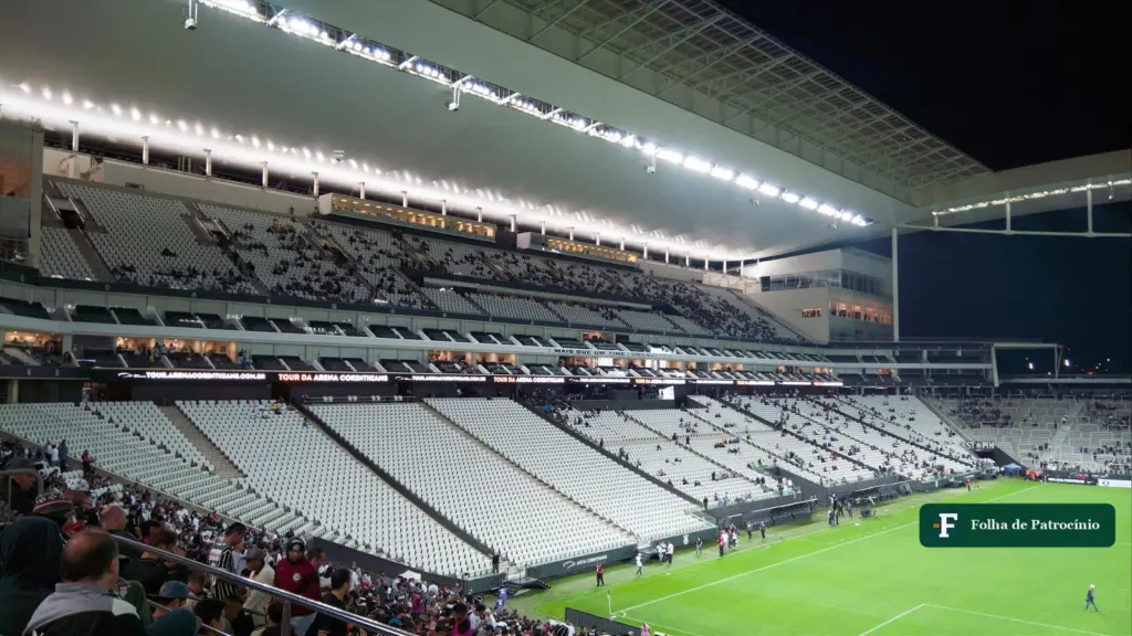 Arquibancadas da arena do Corinthians iluminadas durante jogo
