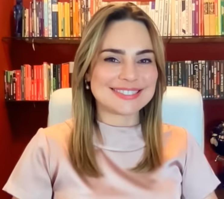 A jornalista Rachel Sheherazade em frente a uma estante de livros