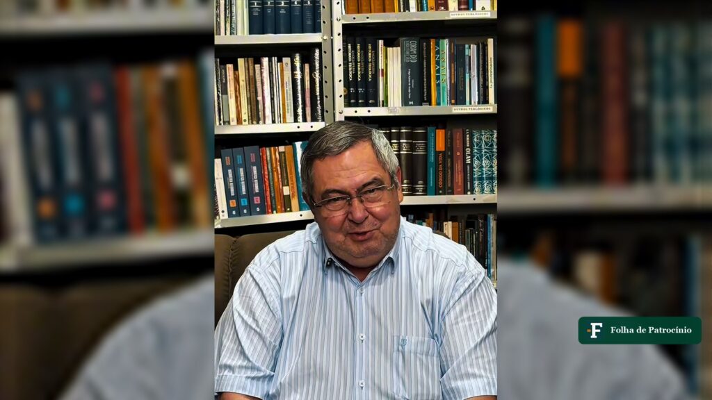 Reverendo Roberto Brasileiro, pastor de Patrocínio, sentado diante de uma estante de livros