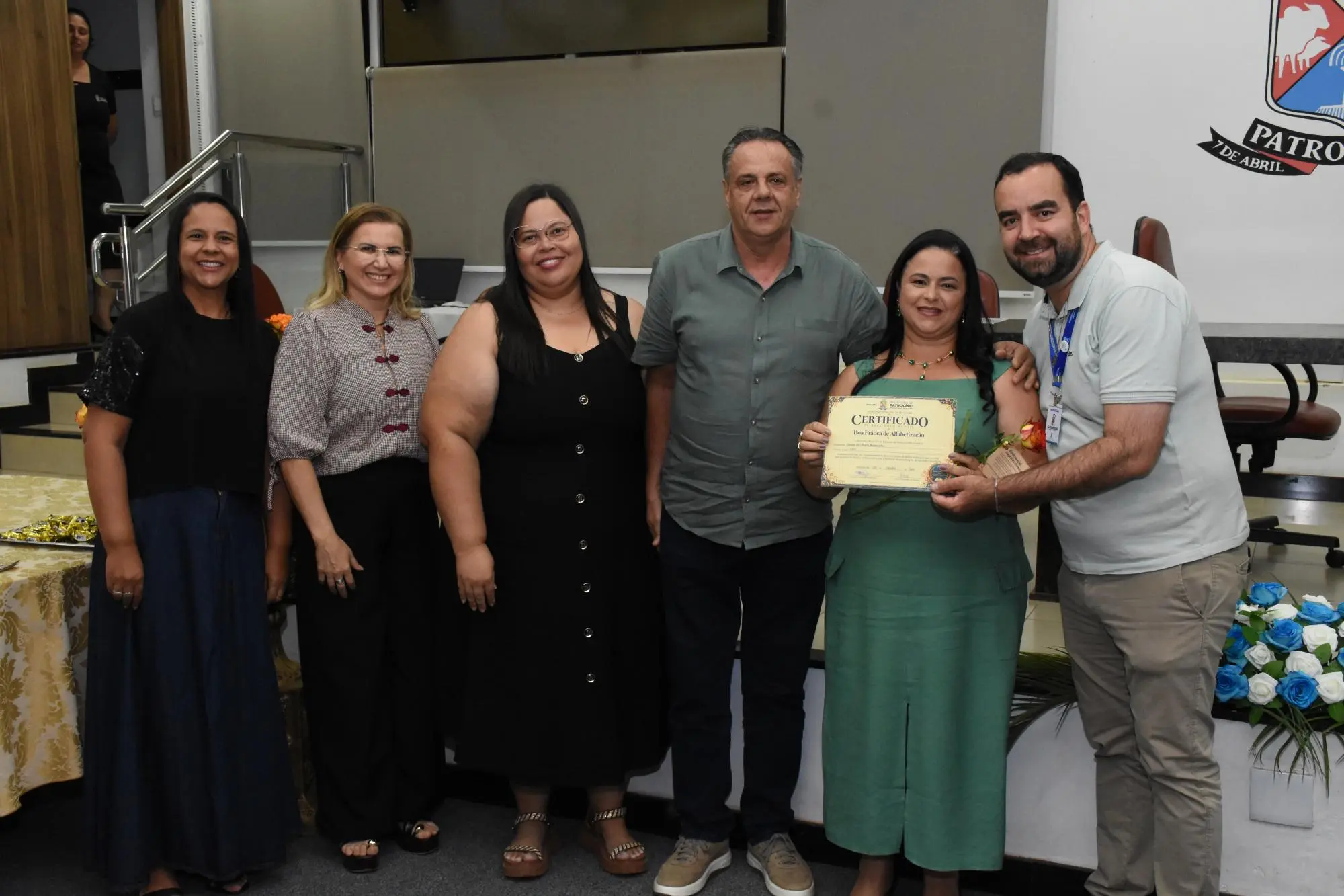 Professora recebe certificado do selo de alfabetização em Patrocínio no palco do auditório