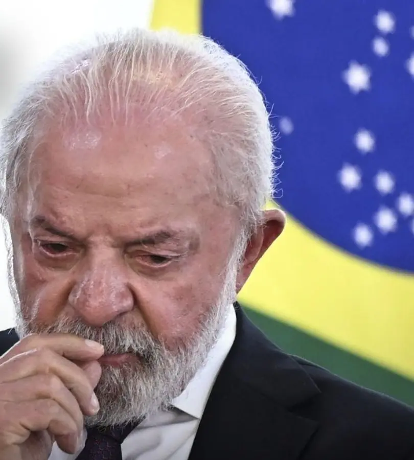Lula com a mão no queixo diante da bandeira do Brasil, no dia em que pediu ao TSE a abertura do sigilo de Lula e da família