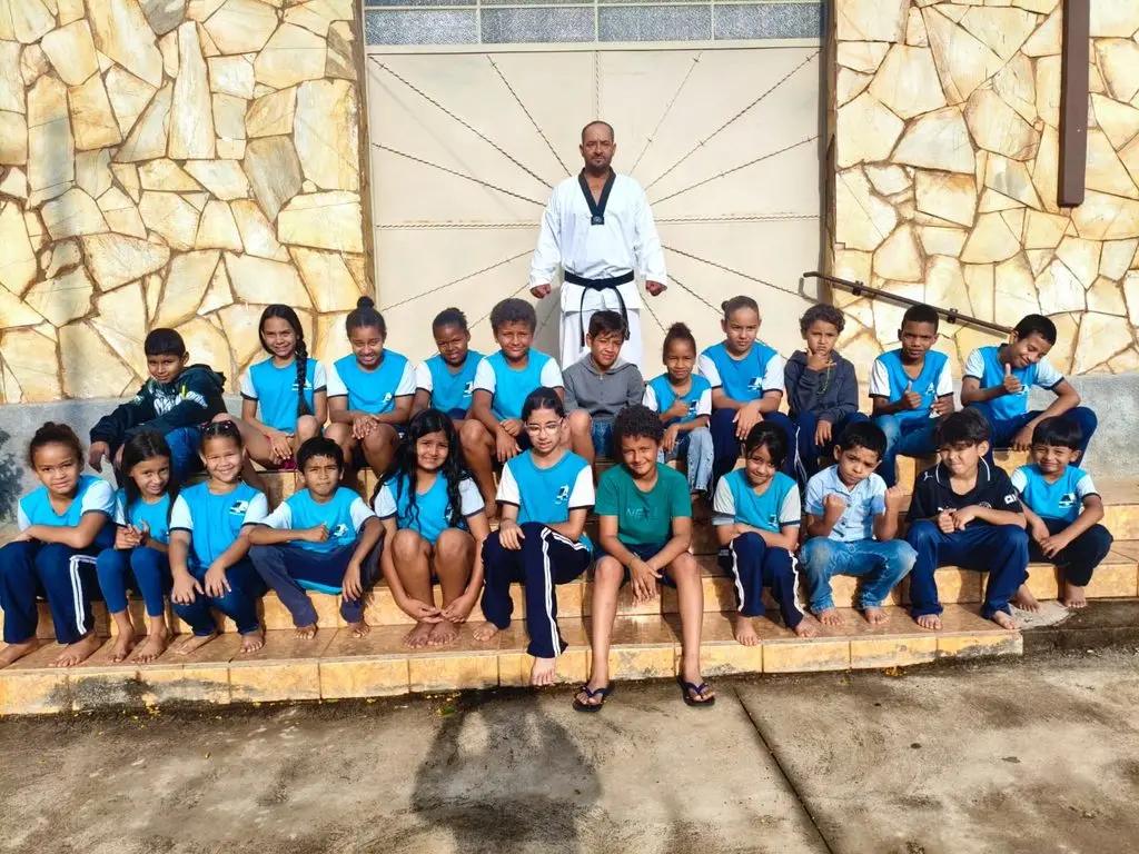 Professor Osmair Alves com alunos de outra escola atendida pelo projeto, antes do taekwondo no Amir Amaral