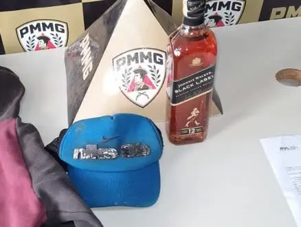 Garrafa de uísque furtado Johnnie Walker Black Label apreendida pela PM em Patrocínio, ao lado de um boné e de uma caixa