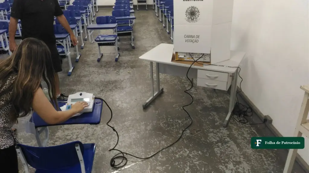 Urnas substituídas no segundo turno: mesária libera a urna eletrônica no terminal do mesário em seção eleitoral de Itajubá (MG)