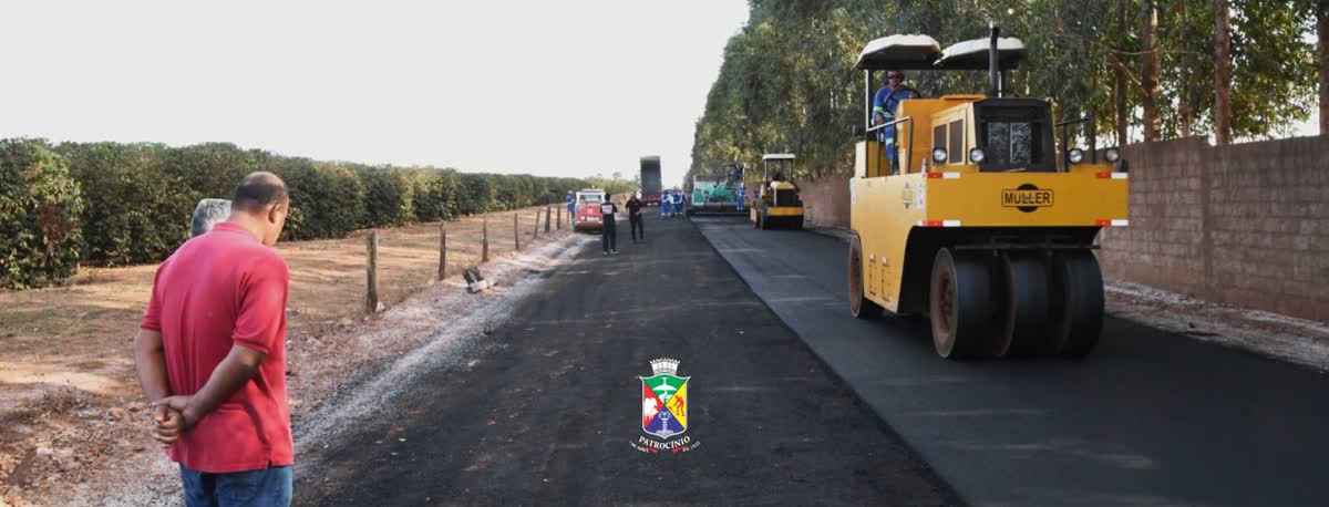 Rolo compactador e pavimentação ao lado de lavoura de café, obra que mobiliza as vagas em Patrocínio na construção civil
